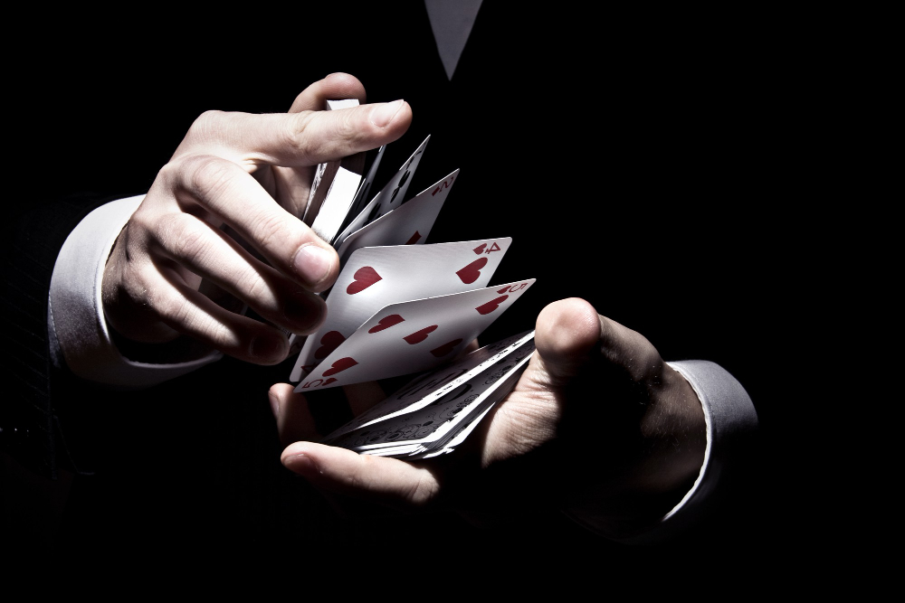 Jogos de cassino: O que jogar? 2 magician shuffling cards cool way spotlight 1