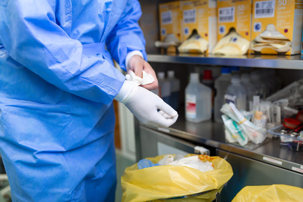 male surgeon removing surgical gloves operation theater hospital