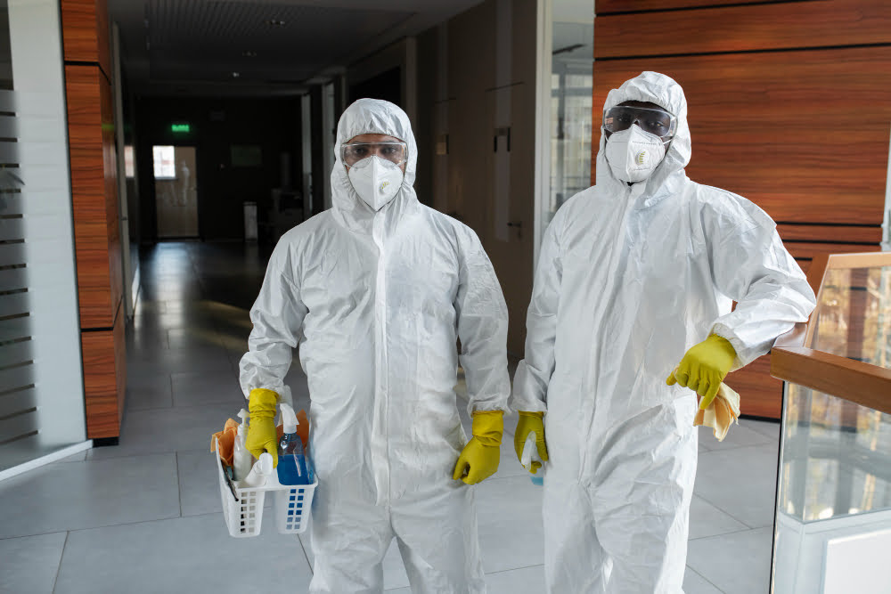 medium shot people cleaning hazmat suits